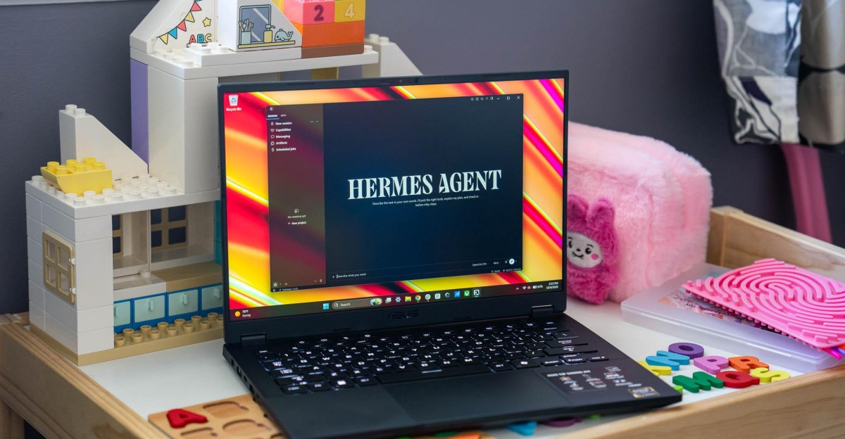 An Asus TUF A14 laptop running Hermes Agent local AI and sitting on a child’s table full of toys.